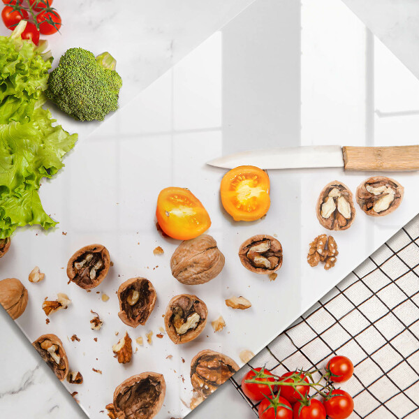 Tabla de cortar de vidrio Nueces sobre un fondo blanco